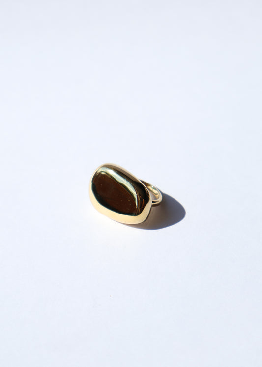 Bague Maria ajustable dorée, modèle de bague bombée posée sur fond blanc