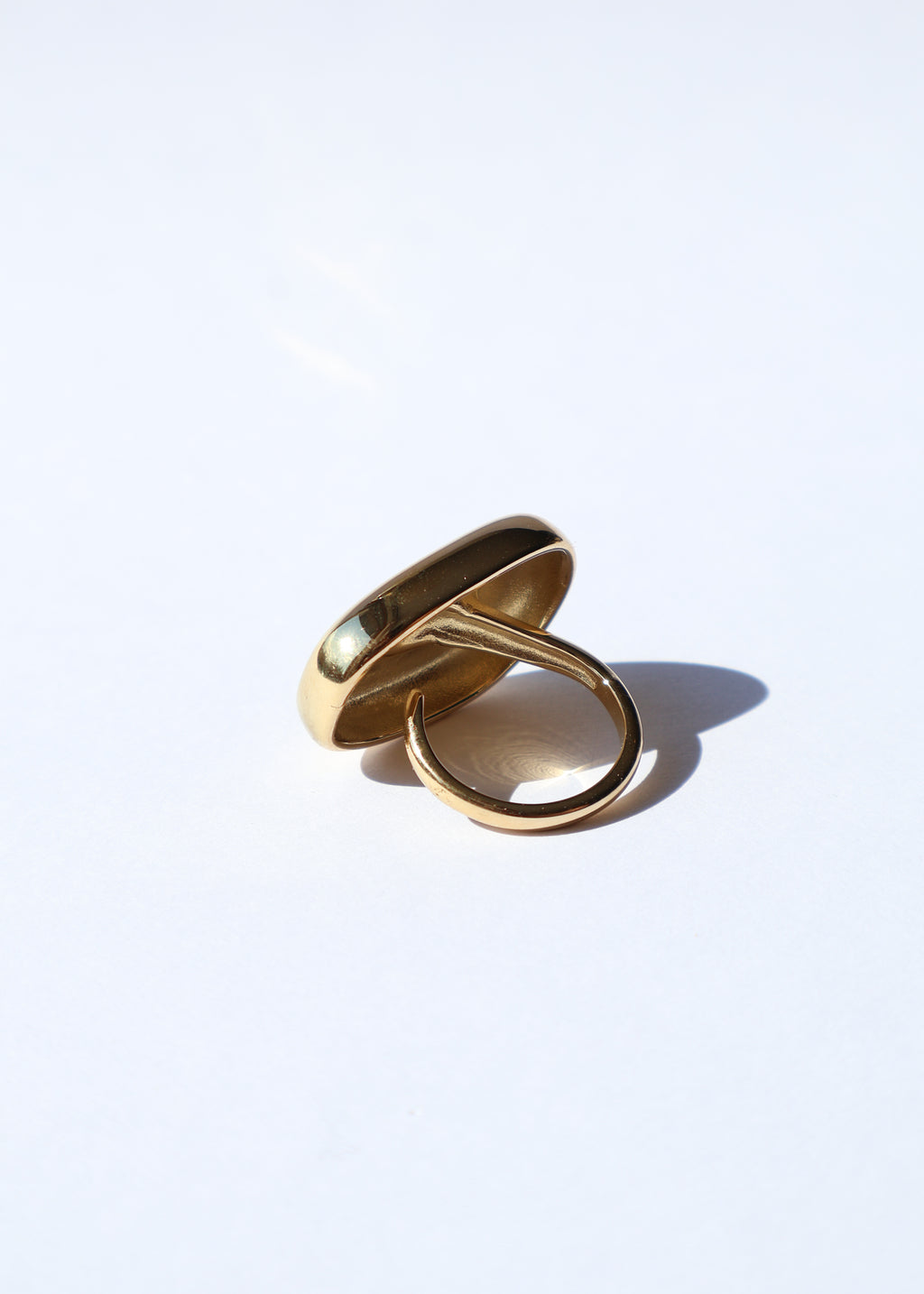 Bague Maria ajustable dorée, modèle de bague bombée posée sur fond blanc