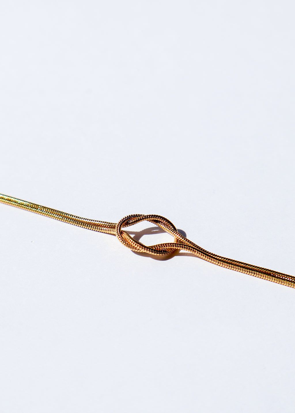 Bracelet en acier inoxydable doré / or, composé d'une chaîne avec un noeud élégant