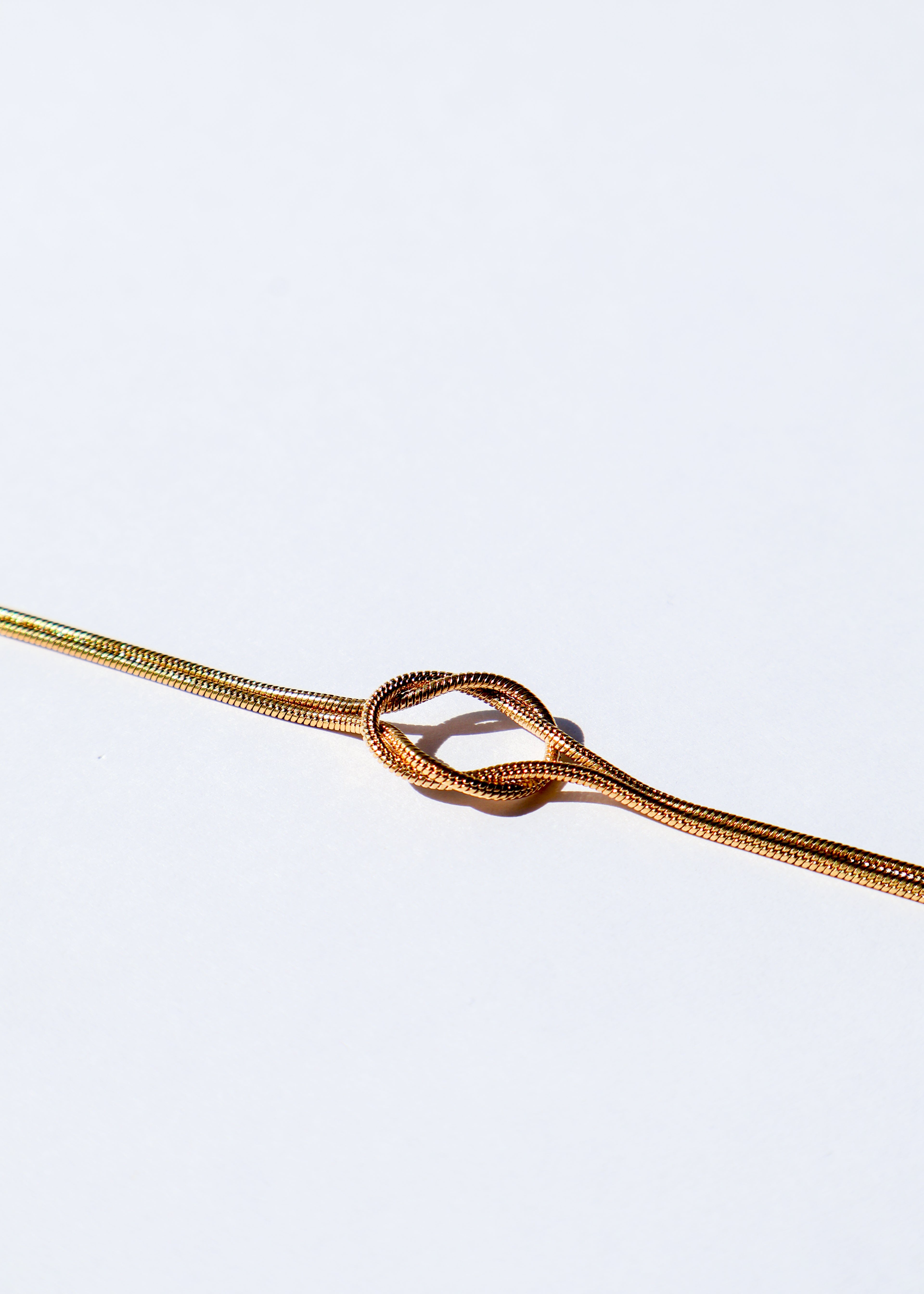 Bracelet en acier inoxydable doré / or, composé d'une chaîne avec un noeud élégant